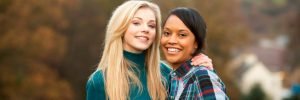 blonde girl and dark haired girl hugging