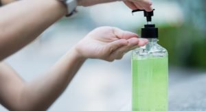 Woman hands using wash hand sanitizer gel dispenser, against Novel coronavirus or Corona Virus Disease (Covid-19) at public Indoor. Antiseptic, Hygiene and Healthcare concept