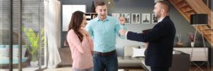 couple receiving keys to their new home from their Realtor - buying a home